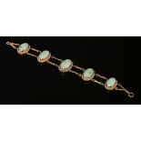 An American jade and seed pearl bracelet,with five graduated oval jade cabochons, each one rub set