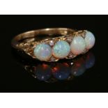 A four stone opal and diamond carved head ring, c.1910,four circular cabochon opals, all claw set to