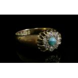 A late Victorian turquoise and diamond cluster ring,with a circular cabochon turquoise, grain set