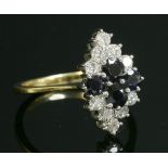 An 18ct gold sapphire and diamond lozenge shape cluster ring,a central quatrefoil cluster of