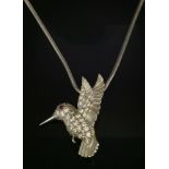 An 18ct white gold, diamond and ruby set hummingbird pendant,by E Wolfe. The pendant with