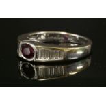 A gold, ruby and diamond ring,by Tiffany & Co., with an oval mixed cut ruby, rub set in a