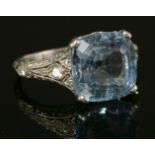 An Art Deco single stone blue topaz ring, with diamond set shoulders and engraved shank, probably