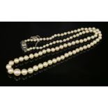 A single row graduated cultured pearl necklace,with an Art Deco diamond and sapphire safety clasp. A