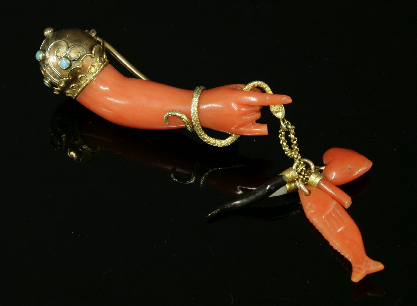 A Victorian gold, carved coral and turquoise set hand brooch, c.1870,the carved coral hand and arm