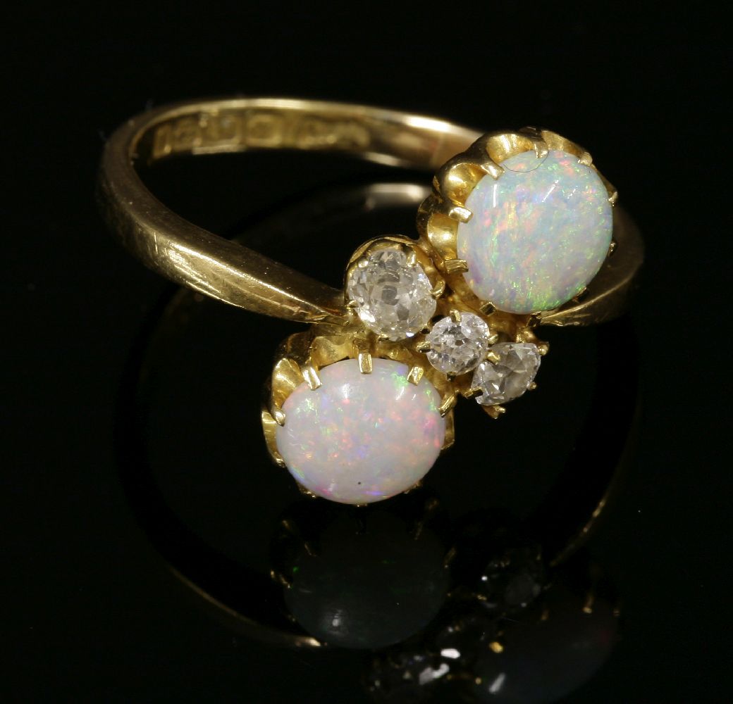 An 18ct gold Edwardian opal and diamond crossover ring,with two circular cabochon opals, claw set in