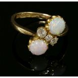 An 18ct gold Edwardian opal and diamond crossover ring,with two circular cabochon opals, claw set in