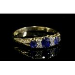 An Edwardian sapphire and diamond, boat-shaped, carved head ring,with three graduated oval mixed cut