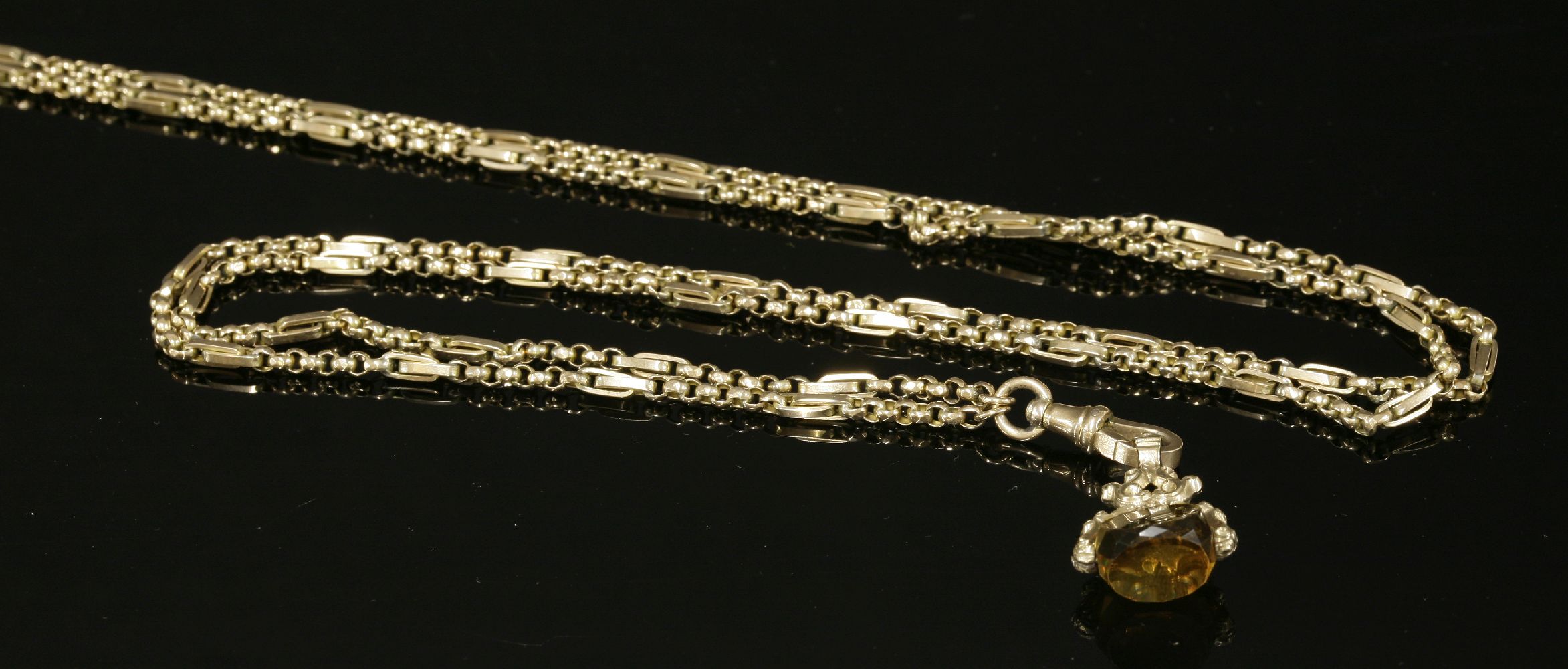 An American gold fancy link guard chain,with sections of faceted belcher chain, with trombone