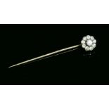 A Victorian diamond set cluster stick pin,with a silver cut down collet at the centre. A surround of