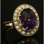 A gold amethyst and split pearl cluster ring,with an oval mixed cut amethyst, claw set to the