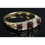 A late Victorian ruby and diamond carved head ring,with an oval mixed cut ruby to the centre and a