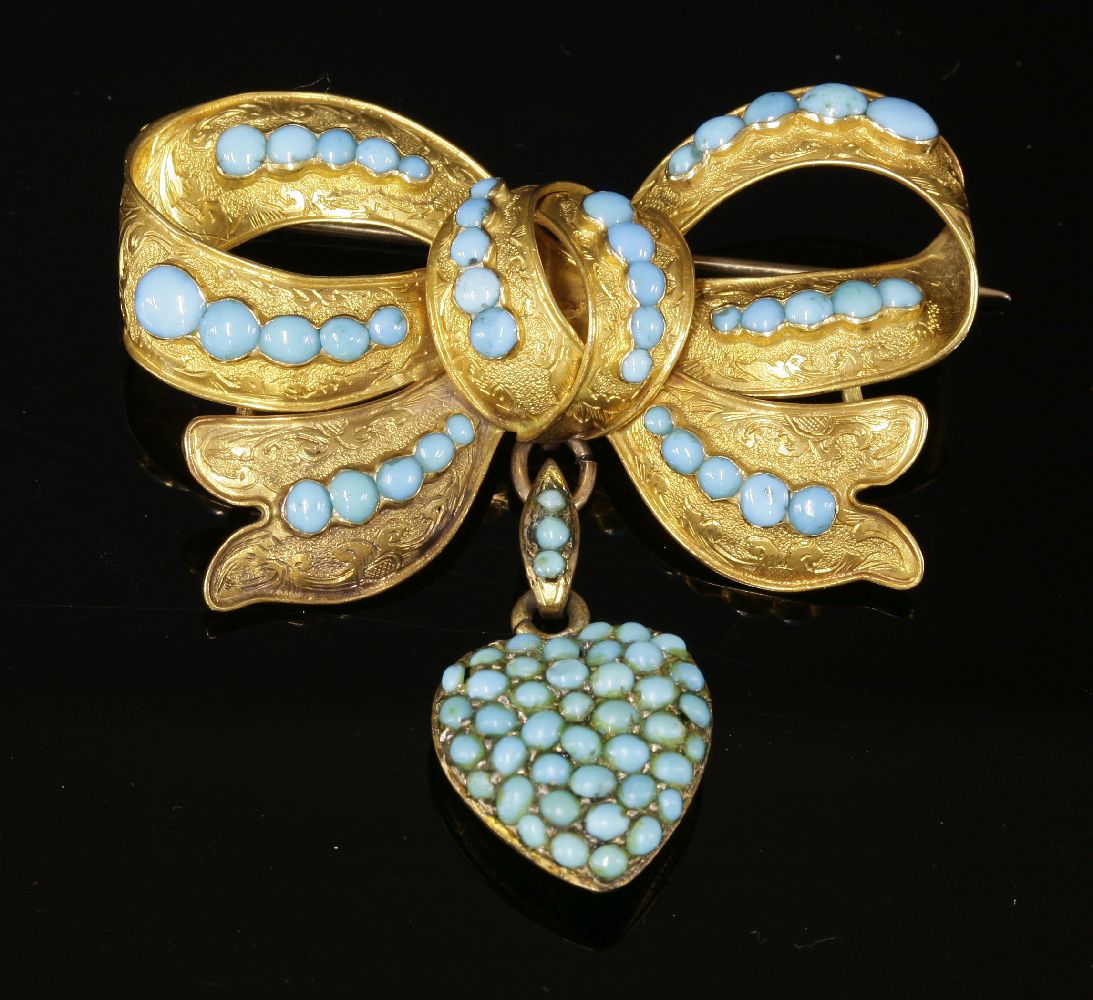 A Victorian gold and turquoise bow brooch, c.1850,with a later heart-shaped pendant drop. The bow