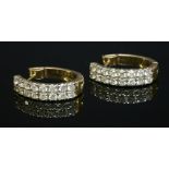 A pair of gold, two-row, diamond set, hinged hoop earrings,two rows of brilliant cut diamonds,