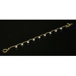 A gold and silver bead link bracelet,with gold curved bar links with silver bead ends, to a