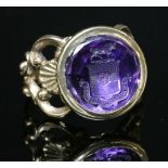 A gold mounted intaglio engraved amethyst seal,later mounted as a ring. A circular amethyst matrix