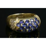 An Italian sapphire and diamond tapered band ring,with four rows of oval mixed cut sapphires,