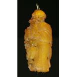 A Chinese carved amber pendant,depicting the immortal, Magu, holding an urn with a deer with pierced