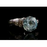 An Art Deco single stone blue zircon ring,with diamond set shoulders. A circular mixed cut blue