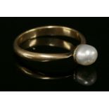 A single stone pearl ring, c.1920,with a pearl, 6.3 x 5.9mm, cup and peg set to low knife edge