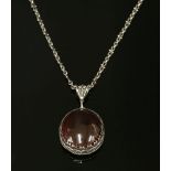 A silver Arts and Crafts garnet pendant,with an oval cabochon garnet set to a collet with a two-