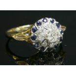 A gold, diamond and sapphire cluster ring,with a central brilliant cut diamond, eight claw set to