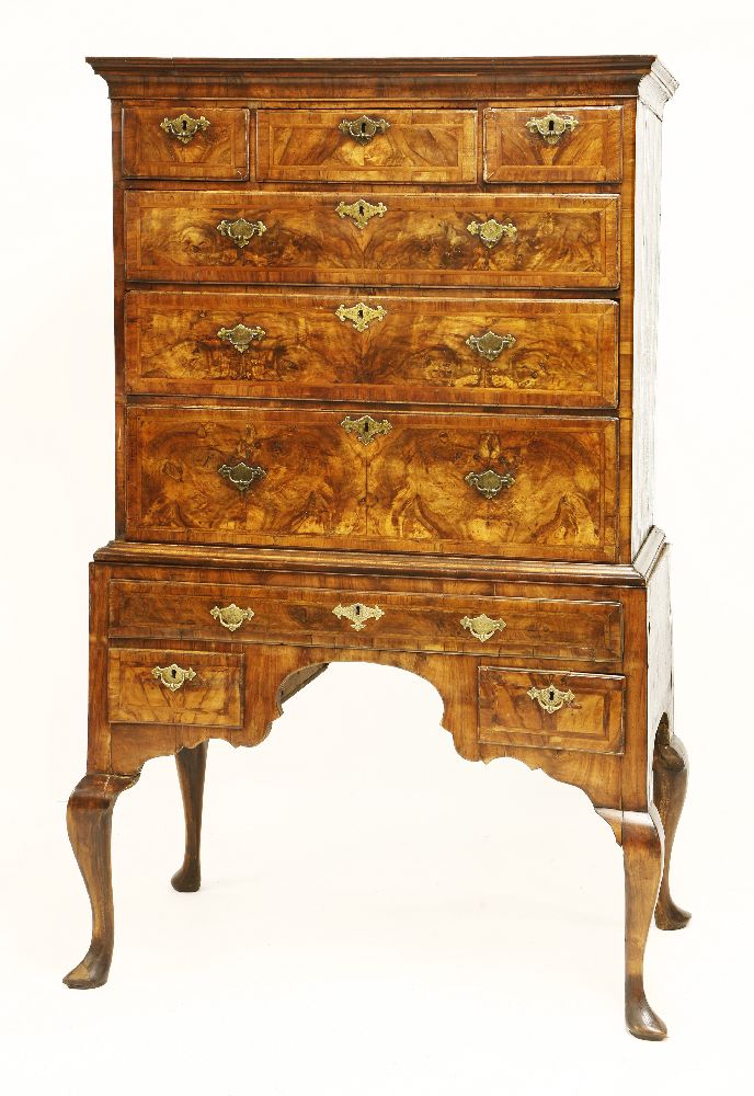 A walnut and feather banded chest on stand, 18th century, the moulded cornice over three short and
