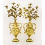 A pair of gilt metal five-branch candelabra,modelled as twin-handled urns with flowers, the urns