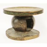 An African softwood stool or headrest,late 19th century, the circular top with a pierced handle on a