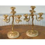 A pair of gilt metal three-light Candelabra on circular white marble bases,