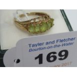 A ladies yellow metal Dress Ring set with five cut peridot,