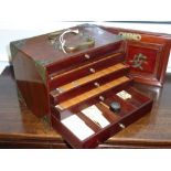 An early/mid 20th century mahogany and brass mounted Mahjong set with bamboo backed bone faced