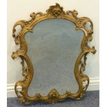 A wall hanging Looking Glass, the shaped gilded frame in high Rococo style (early 20th Century),