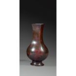 ƒ VASE BOUTEILLE ARCHAÏSANTen bronze de belle patine sombre infusée de rouge, monté sur un petit