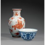 VASE BOUTEILLEen porcelaine, rouge de fer et dorure, la panse ovoïde, à décor, logé dans trois