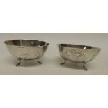 A pair of 20th Century small silver bowls on three paw supports, each marked "Silver 830" one