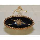 A Victorian gold (tested) oval mourning brooch, set with oval black glass panel (A/F) with central