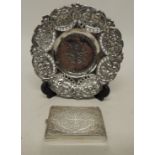 A small Oriental circular silver dish embossed with floral and figural design, 15cms diam together