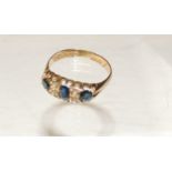 An 18ct gold ring set with three oval, faceted sapphires and four white sapphires, in an openwork