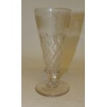 A 20th Century tall glass goblet with etched fruiting vine and faceted decoration and on short