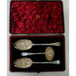 A George III cased silver berry spoon and sugar sifter set, the plush velvet lined case containing a