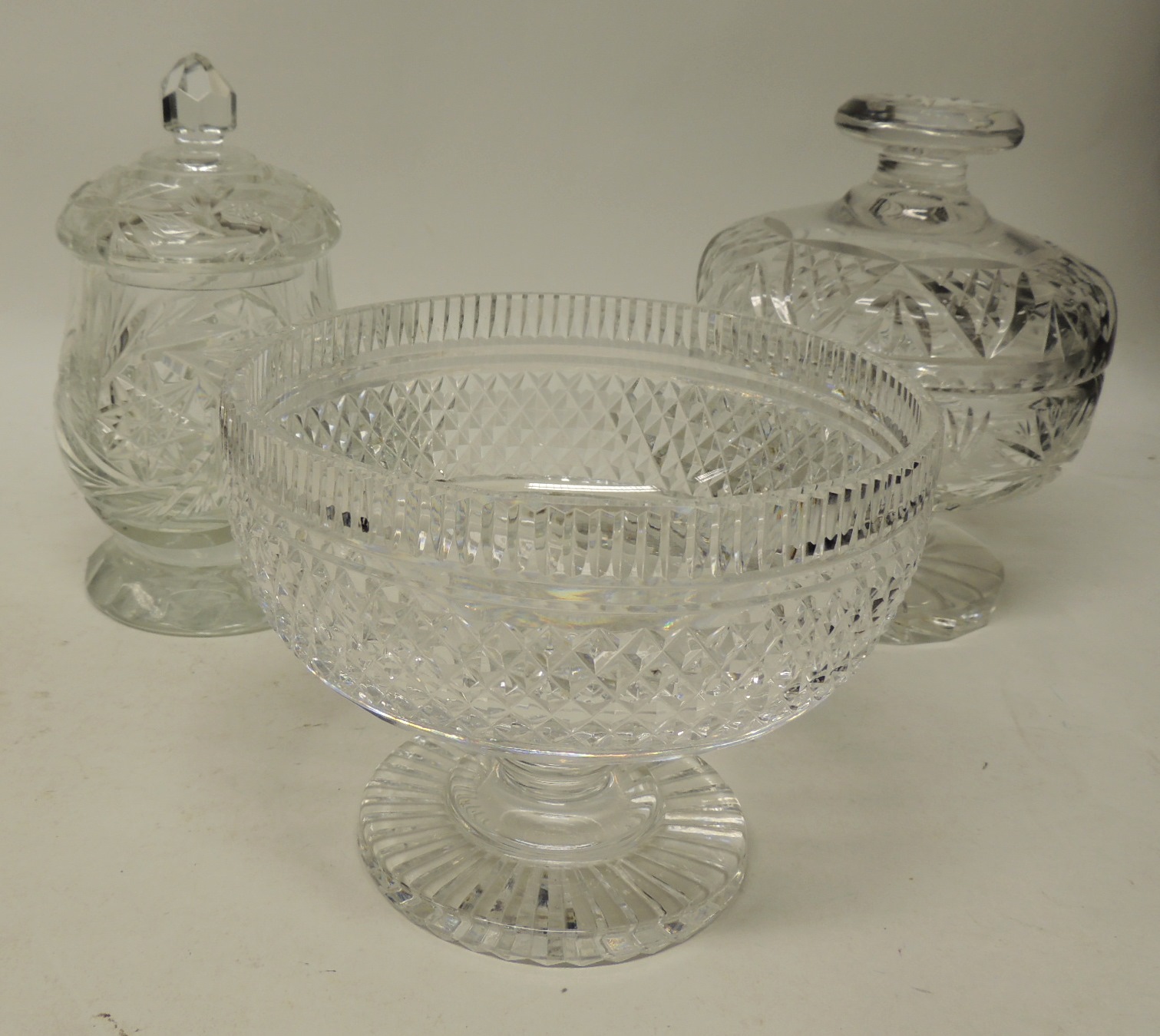A heavy cut crystal pedestal bowl, 14.5cms high; a cut glass bon bon dish and cover and another