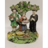 A 19th Century Staffordshire Tithe Pig pottery group with a Rector, man holding pig, woman holding