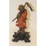 An early 20th Century Chinese Foochow lacquered wood figure of a man standing and holding a staff,