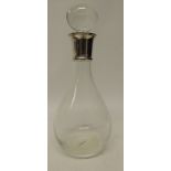 A glass decanter and stopper with silver collar, 31cms high