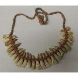 An interesting (deer ?) tooth necklace, made from twenty seven teeth, each individually knotted with