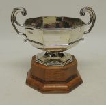 An octagonal silver two handled trophy on low pedestal and on octagonal oak base, Sheffield 1939,