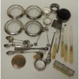 A set of four silver rimmed glass bowls; napkin rings; silver handled cutlery and other decorative