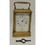 A late 19th Century carriage clock with hour repeat and alarm, having white enamel dial inscribed