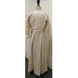 An Edwardian cream silk ladies dress with machine lace inset panels and fitted to the waist together